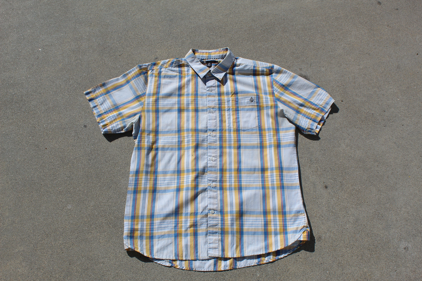 Plaid short-sleeve shirt on a gray surface

