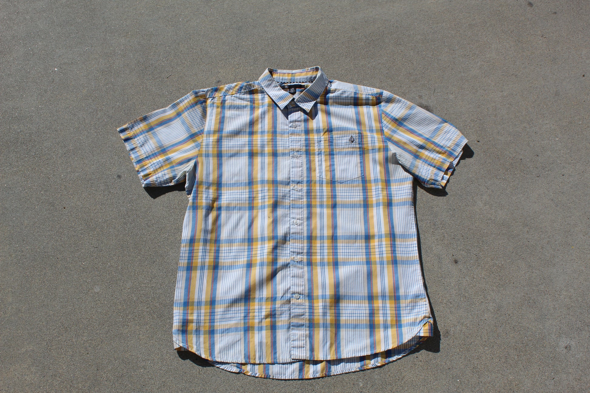 Plaid short-sleeve shirt on a gray surface

