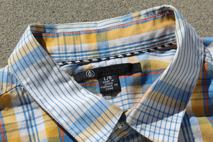 Plaid shirt with collar and label on a textured surface

